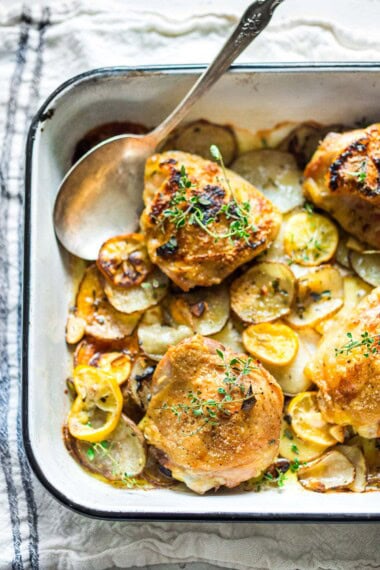 These easy oven-baked chicken thighs are roasted over thinly sliced potatoes with garlic, lemon and thyme. A delicious, easy sheet pan dinner with only 10 minutes of prep time, before baking in the oven.