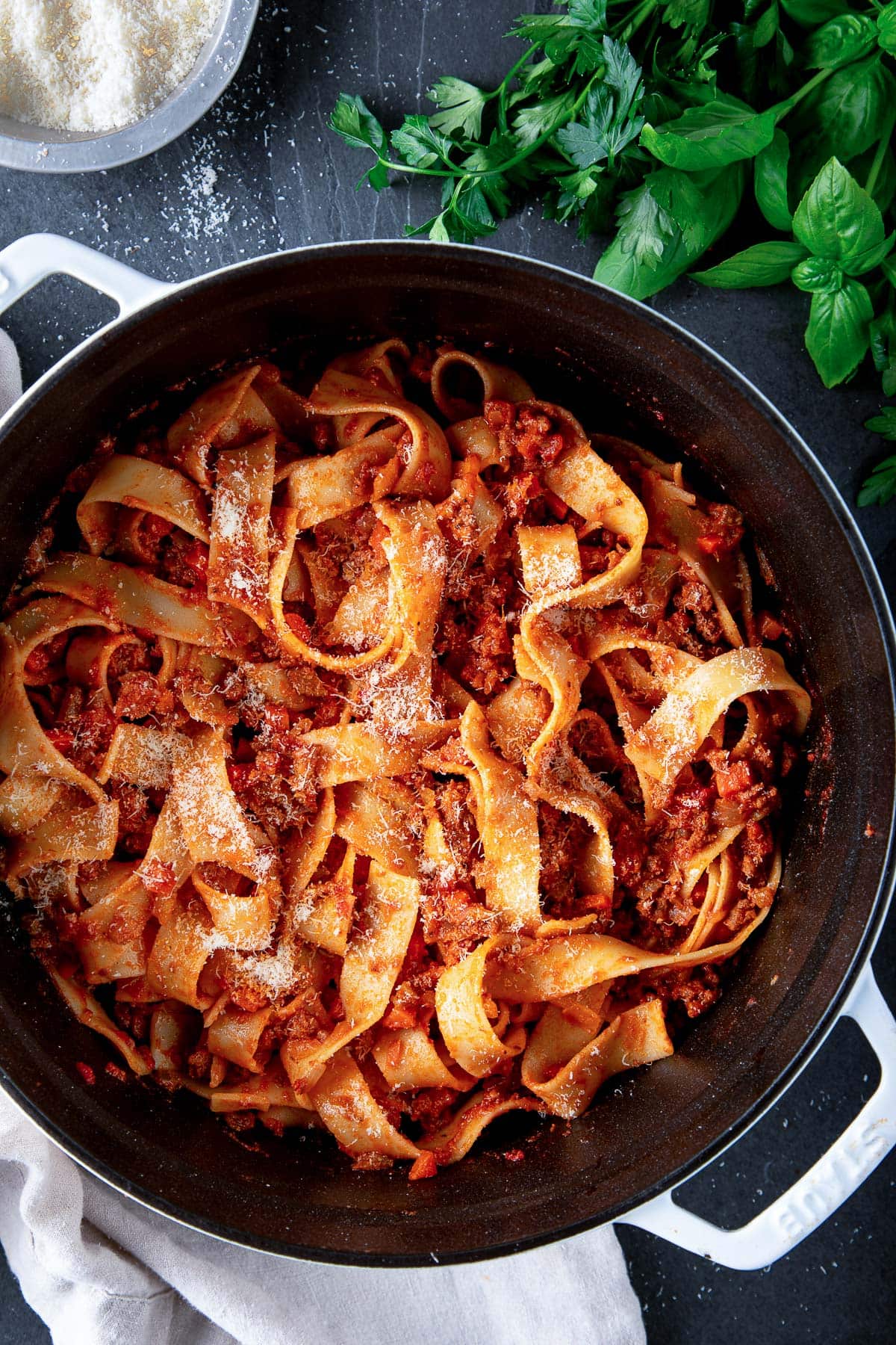 large dutch oven with bolognese sauce tossed with pappardelle with grated pecorino.