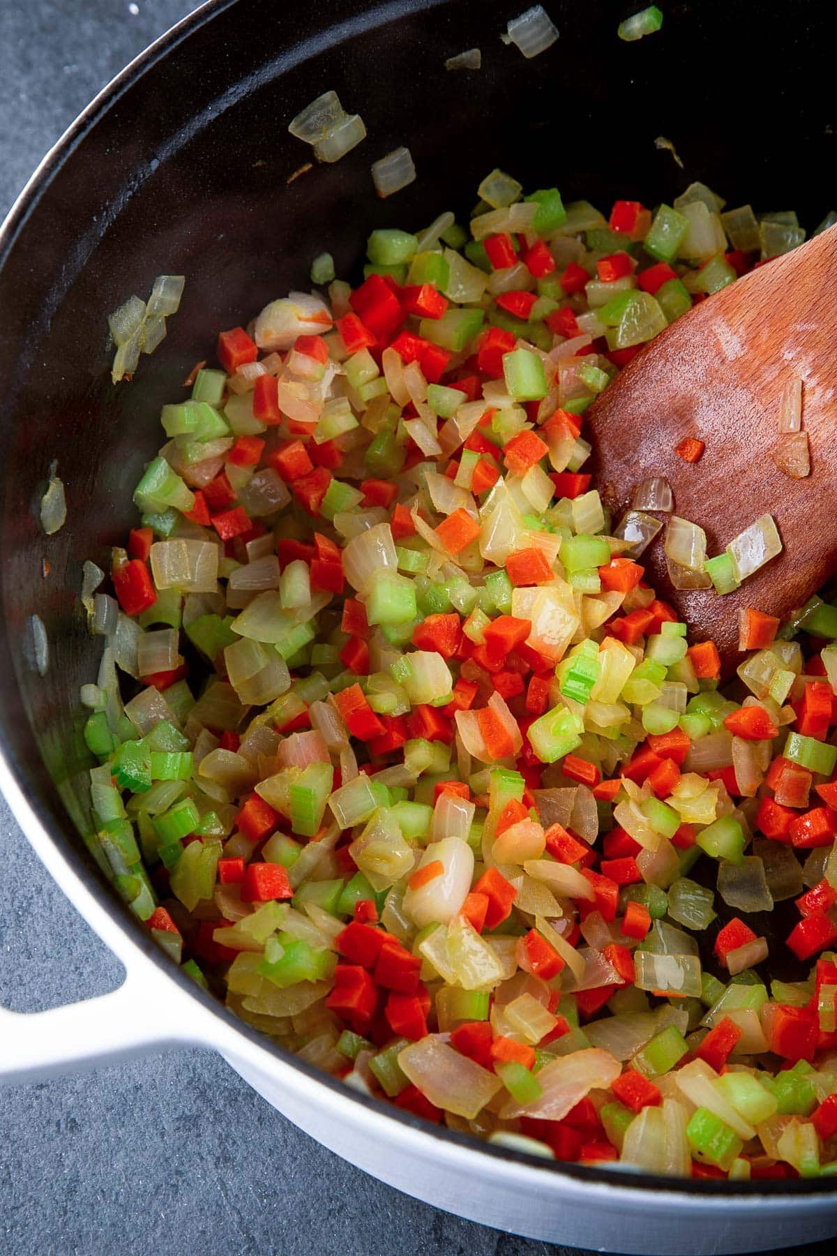 large dutch oven with sautéed diced carrots, celery, and onion.