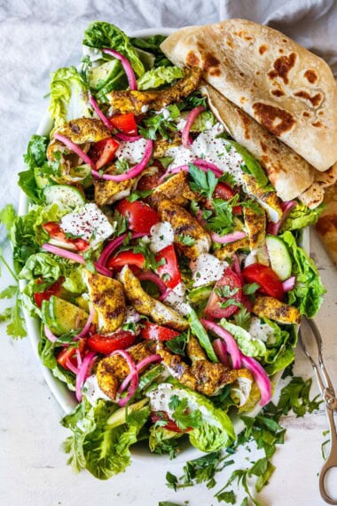 Mouth-watering, crunchy, fresh goodness is here in this amazing Grilled Chicken Salad! Made with little gem lettuce, grilled shawarma chicken, pickled onions and topped with tahini yogurt dressing.